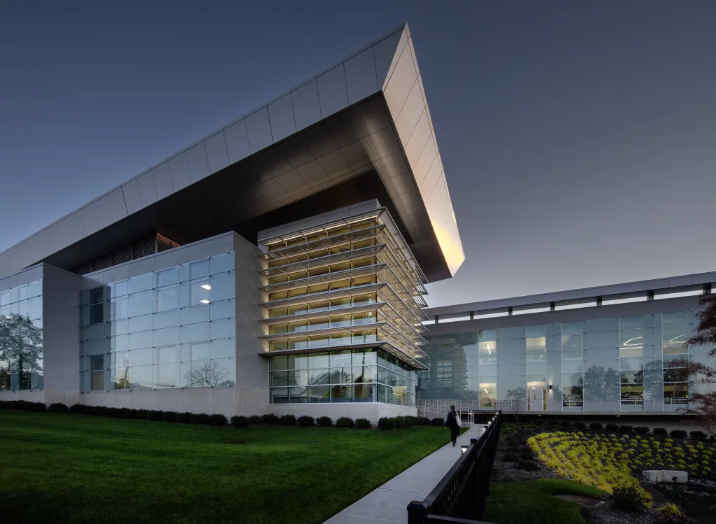 Exterior of Essex County College’s West Essex Campus at dusk, with a projecting metal roof, glass facade, and landscaped approach.